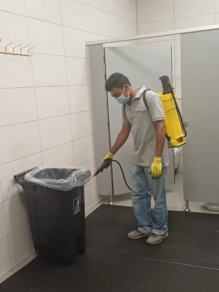 Safe Guard technician spraying a washroom in a commercial building